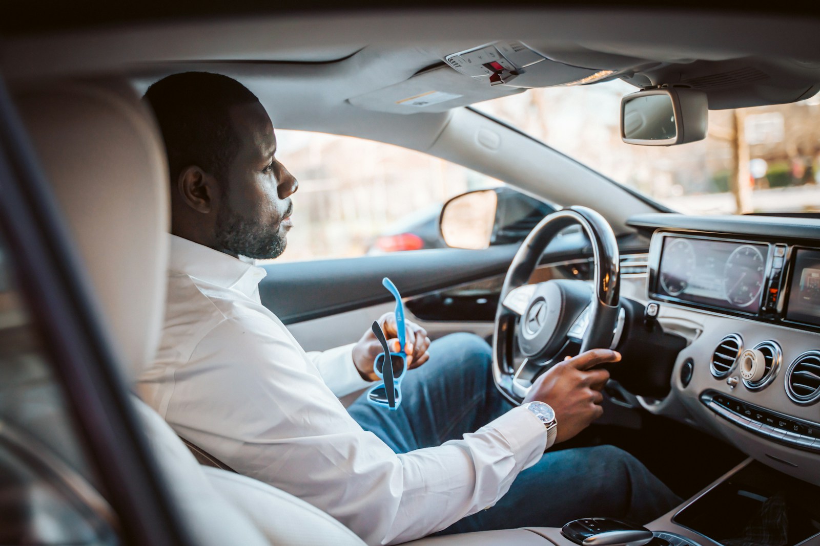 man in white dress shirt driving car during daytime, driving